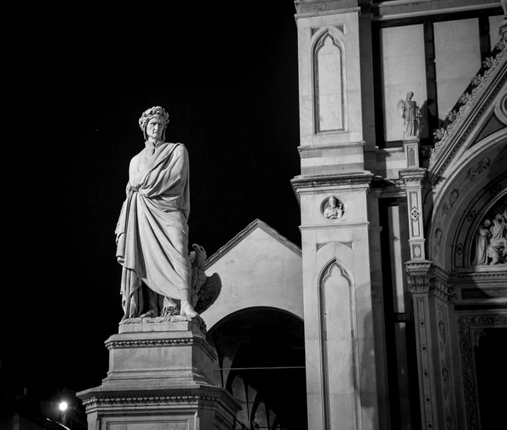 A statue of a man in front of an old building.