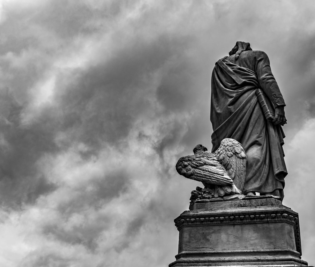 A statue of a man and a bird on top of a pillar.